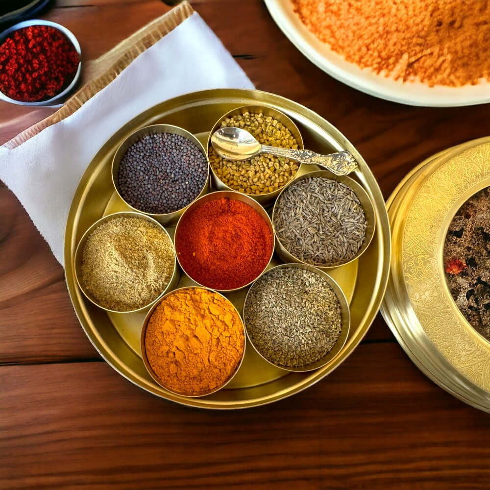 Elegant brass spice container with assorted spices in circular arrangement for kitchen cooking.
