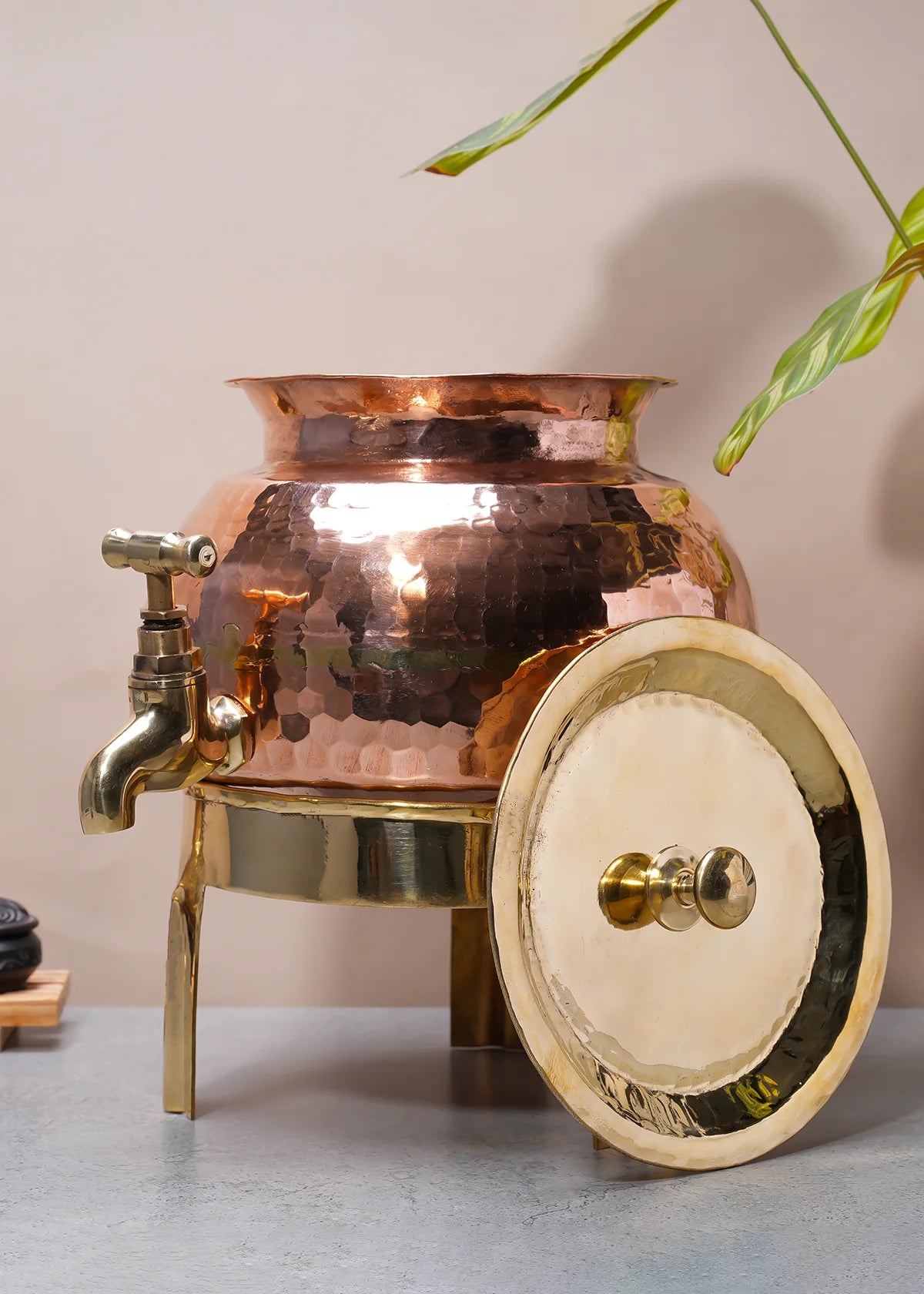 Elegant copper water dispenser with brass tap, beautifully crafted and showcased on a minimalistic background.